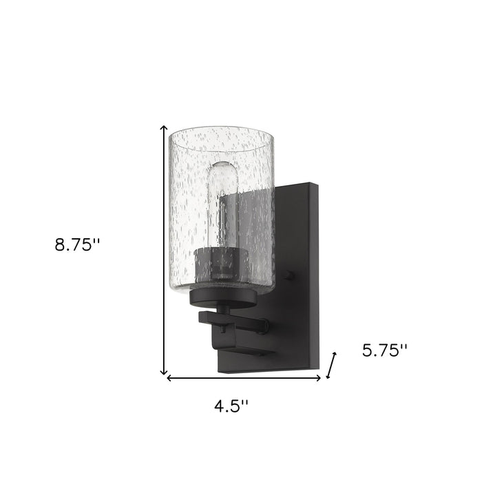 Bronze metal wall sconce with clear seeded glass shade – modern indoor wall lighting fixture shown with dimensions of 8 point 75 inches high by 4 point 5 inches wide by 5 point 75 inches deep