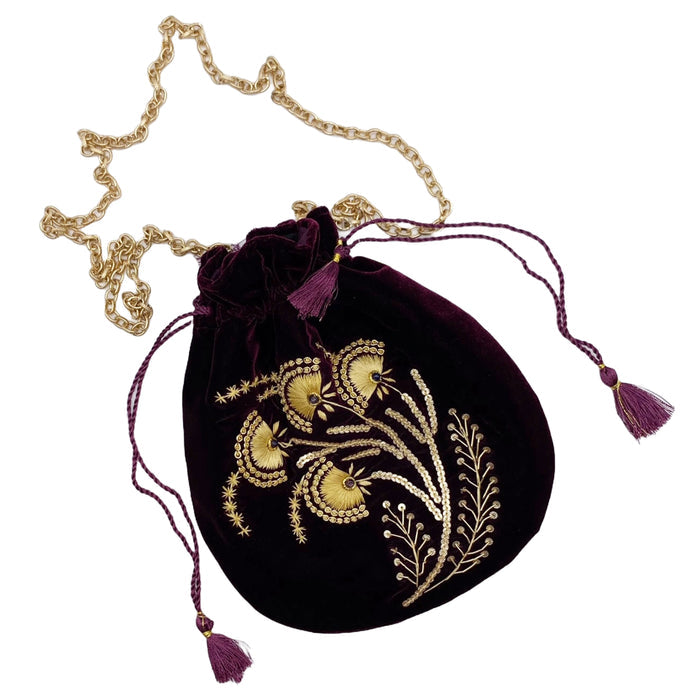 A purple velvet pouch with gold beadwork and embroidery, featuring a gold-toned chain and purple tasseled drawstring.