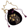 A purple velvet pouch with gold beadwork and embroidery, featuring a gold-toned chain and purple tasseled drawstring.