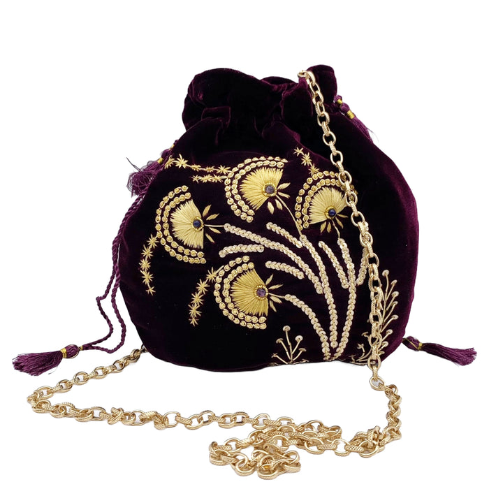 A purple velvet pouch with gold beadwork and embroidery, featuring a removable gold-toned chain and purple tasseled drawstring.