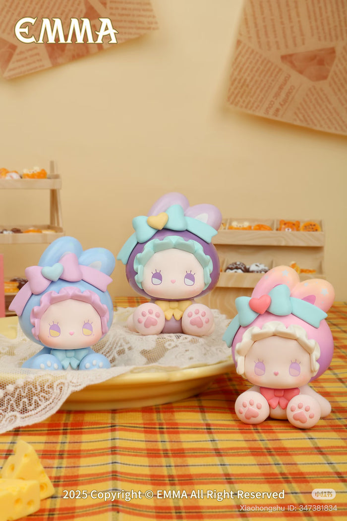 Emma Bunny Collector Mini Blind Box Series figurines on a lace plate, showcasing three pastel-colored bunnies in bonnets, part of a collectible preorder set.