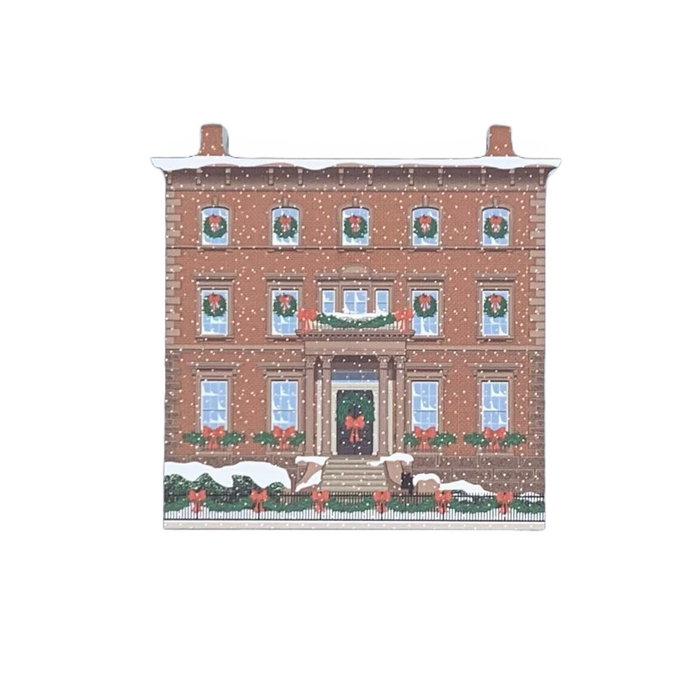 A decorative block featuring the John Tucker Daland House, depicted with holiday decorations.