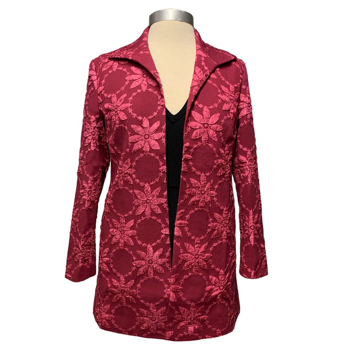 A pink floral applique jacket on a mannequin displaying an open front design with long sleeves.