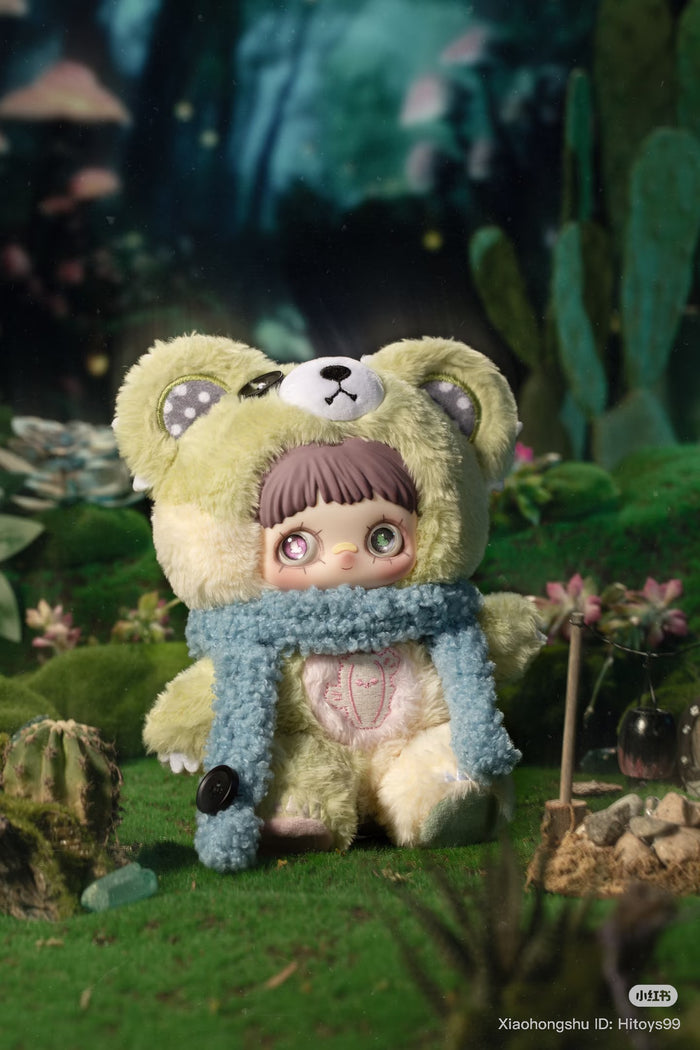 MayMei Symbiote Neverland Series Vinyl Keychain Plush Blind Box featuring a doll in a bear costume, set in a miniature diorama with tiny plants and a campfire.