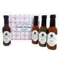 Four bottles of Lighthouse Keepers hot sauce with a decorative box in the background.