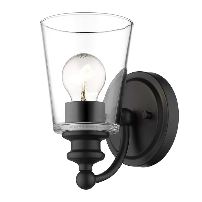 Bottom up angled view of the lighted One-Light Matte Black Wall Sconce with clear tapered glass shade and curved arm design