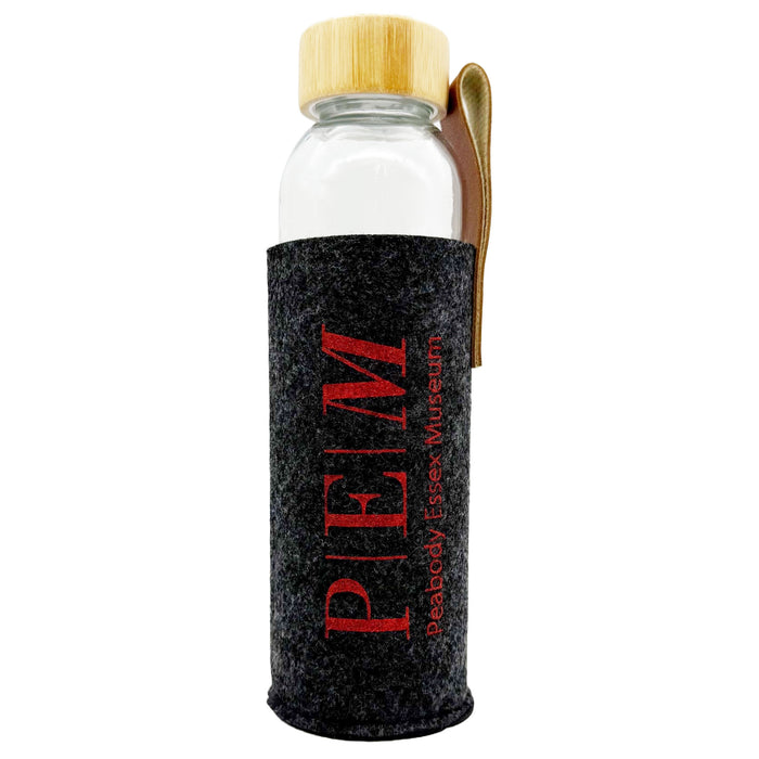 Clear glass water bottle with grey felt sleeve featuring red PEM logo and Peabody Essex Museum text on a white background