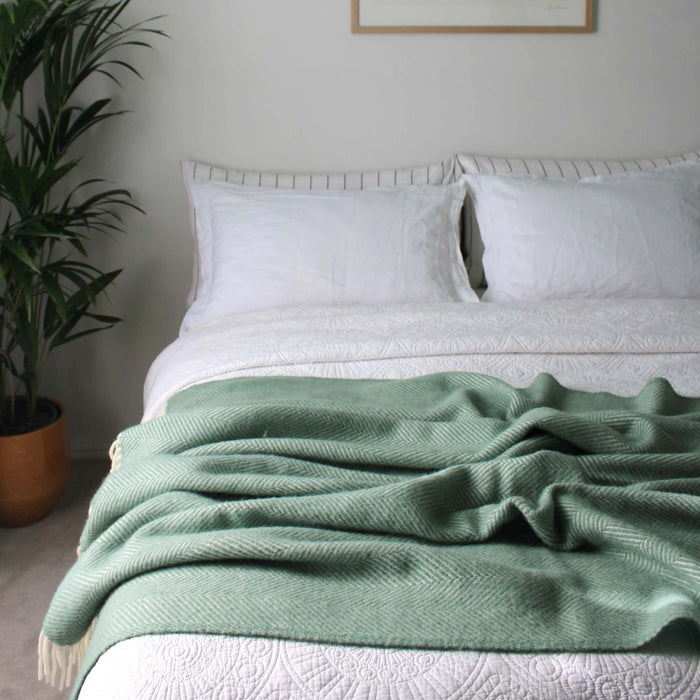 Sea Green Herringbone Pure Wool Throw in a styled bedroom 1 | Soak and Sleep