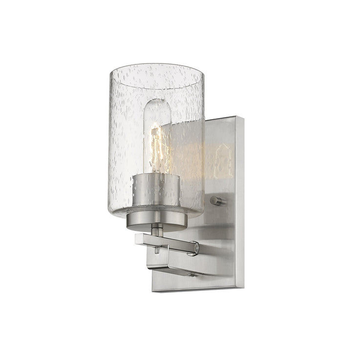 Right bottom up angle view of the lighted Silver metal wall sconce with raindrop-textured glass shade, modern single-light design