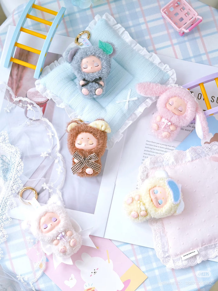 Sleepy Baby series vinyl plush keychain blind box displayed with stuffed animals, featuring preorder details for Strangecat Toys' art-inspired blind box collection.