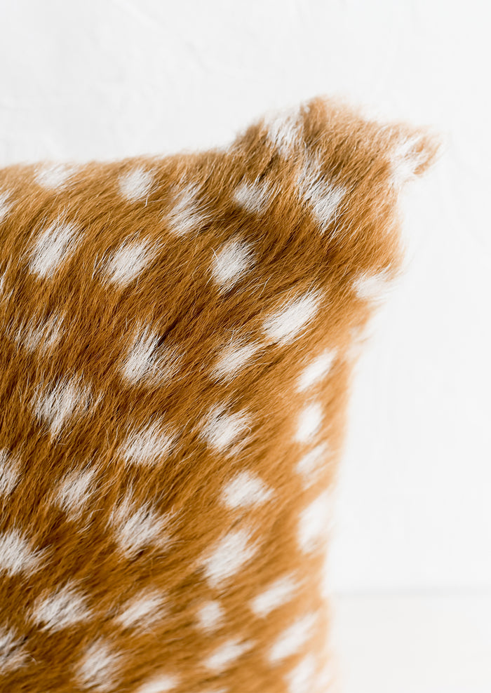 A pillow made from spotted goat fur.