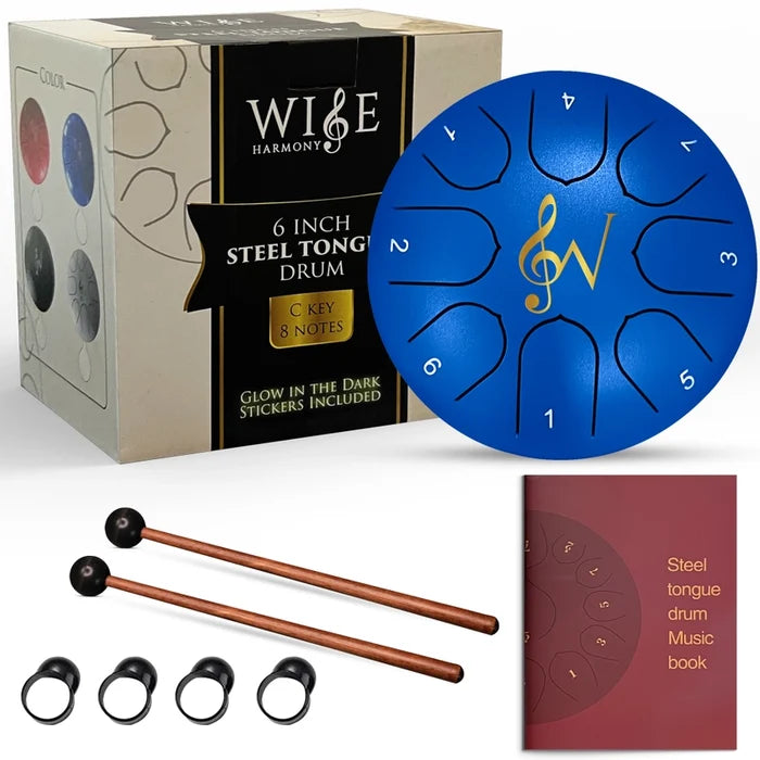 Blue steel tongue drum with packaging, mallets, and music book on a white background
