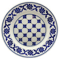 A round porcelain tea plate with a blue and white floral pattern reproduced from the Ropes Mansion fireplace surround tiles.