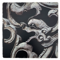 A square trivet with a printed image of a carved Dragon Gate lattice screen in a dark color.