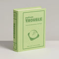 Green book-shaped product with 'papomatic Trouble' branding on a gray background