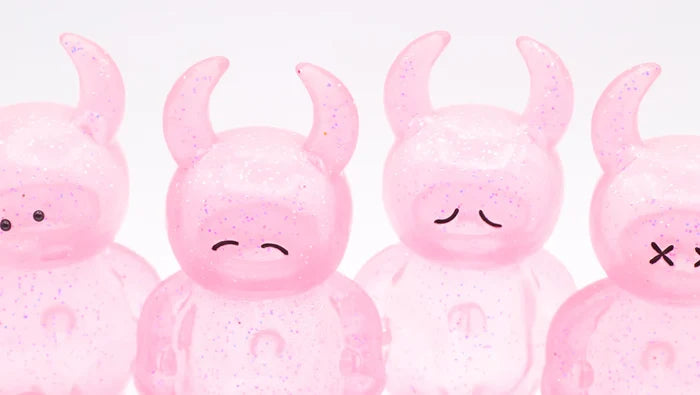 UAMOU CLEAR PINK GLITTER figures, 7cm tall, translucent and glitter-filled, each with unique painted expressions and horns, crafted from soft vinyl in Japan.