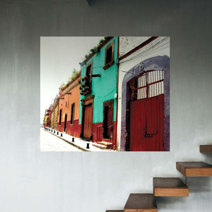 48 inch colorful Mexican street scene with buildings decal installed on a wall next to wooden steps.