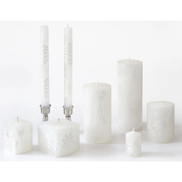 Set of white candles with decorative patterns on a white background