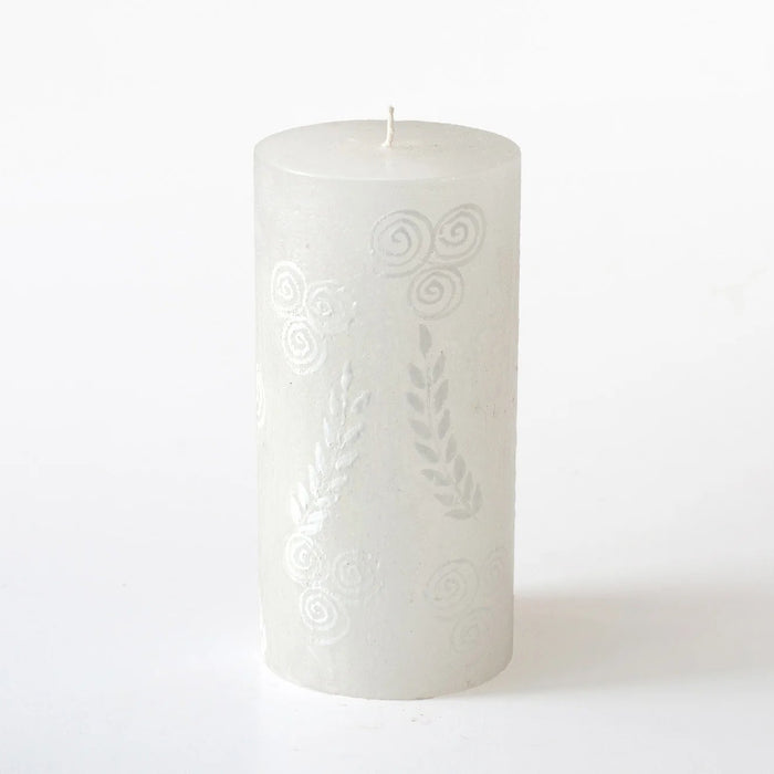 White candle with embossed design on a white background