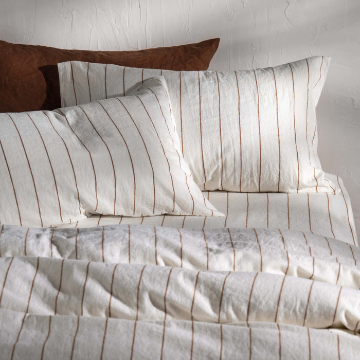 White/Burnt Orange Pinstripe Linen Cotton Blend Bedding styled in a bedroom | Soak and Sleep