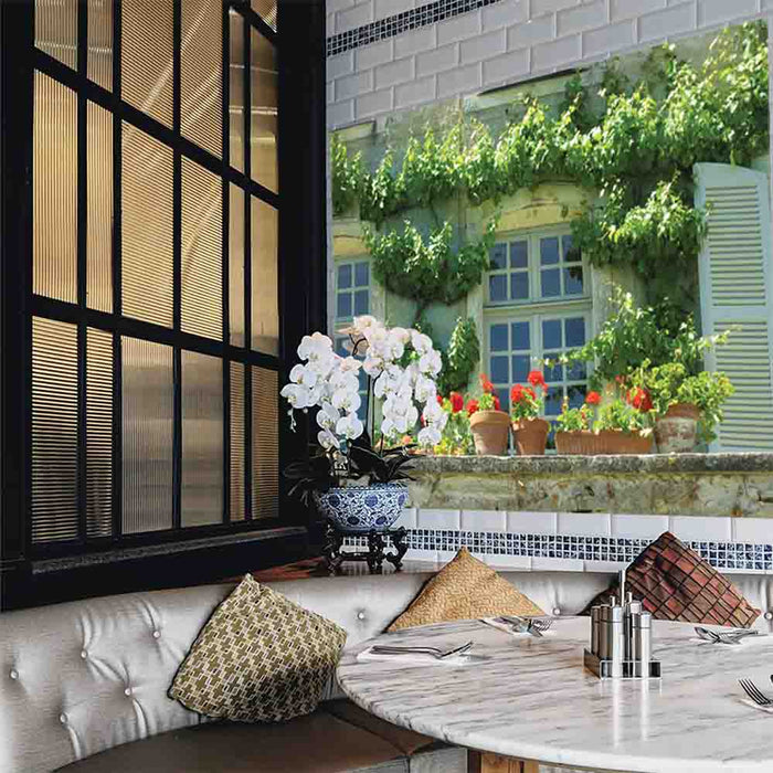 60 inch decal of a terrace in Auvillar France with ivy and flowerpots installed on a wall in a restaurant booth