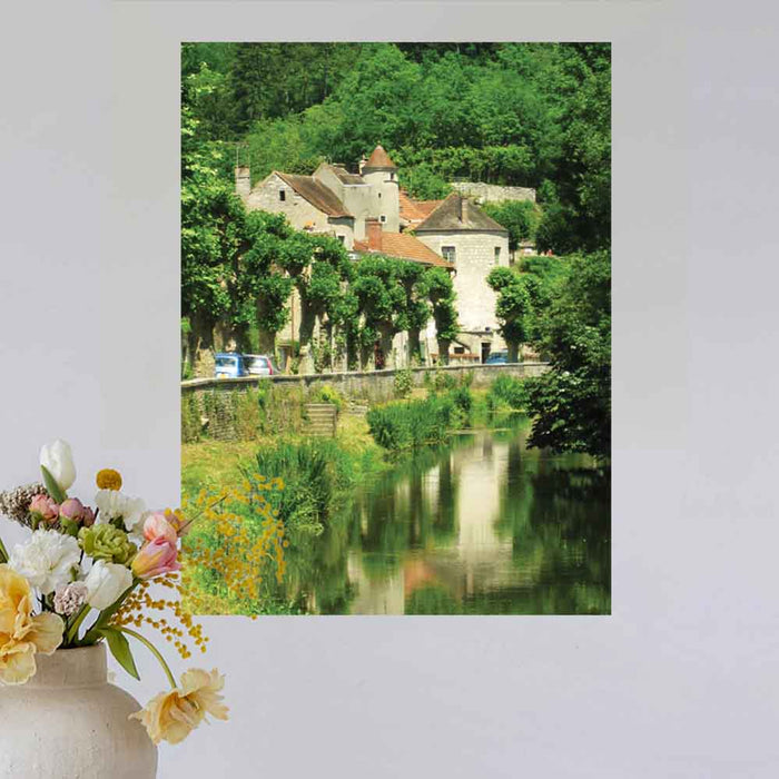 24 inch decal of a stone building in France along a river installed on a wall above vase of flowers